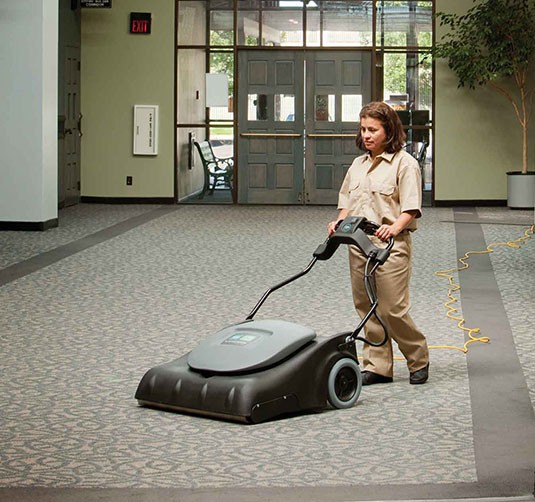 A custodian using the Tennant V-WA-30 Wide Area Vacuum.