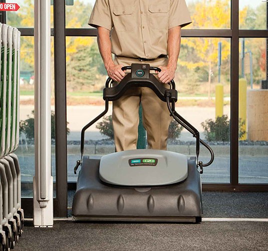 Employee vacuuming front entrance with the V-WA-30 Wide Area Vacuum.