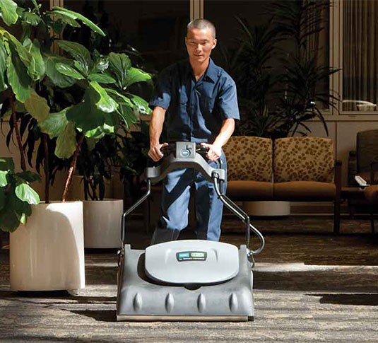 A custodian using the V-WA-30 Wide Area Vacuum in a hospital.
