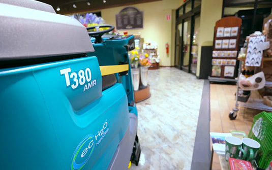 lavadora robótica de pisos Tennant T380 a limpar em redor de artigos num supermercado